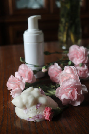 Rose foam cleanser surrounded by roses and soap foam